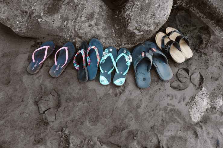assorted flip flops on sand